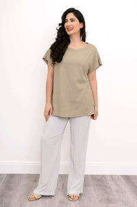 Woman in beige dolman sleeve tee looking to the side
