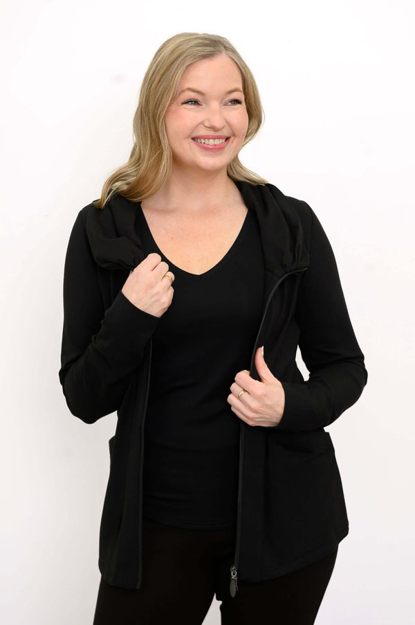 Woman wearing a black hoodie jacket and black V-neck shirt, jacket partially unzipped