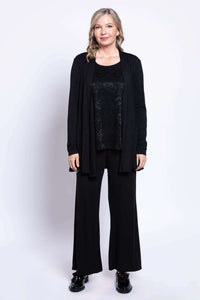 Woman in black lace tank, cardigan, and wide-leg pants, full body view