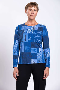 Woman wearing a blue botanical print long sleeve tee with black pants, front view