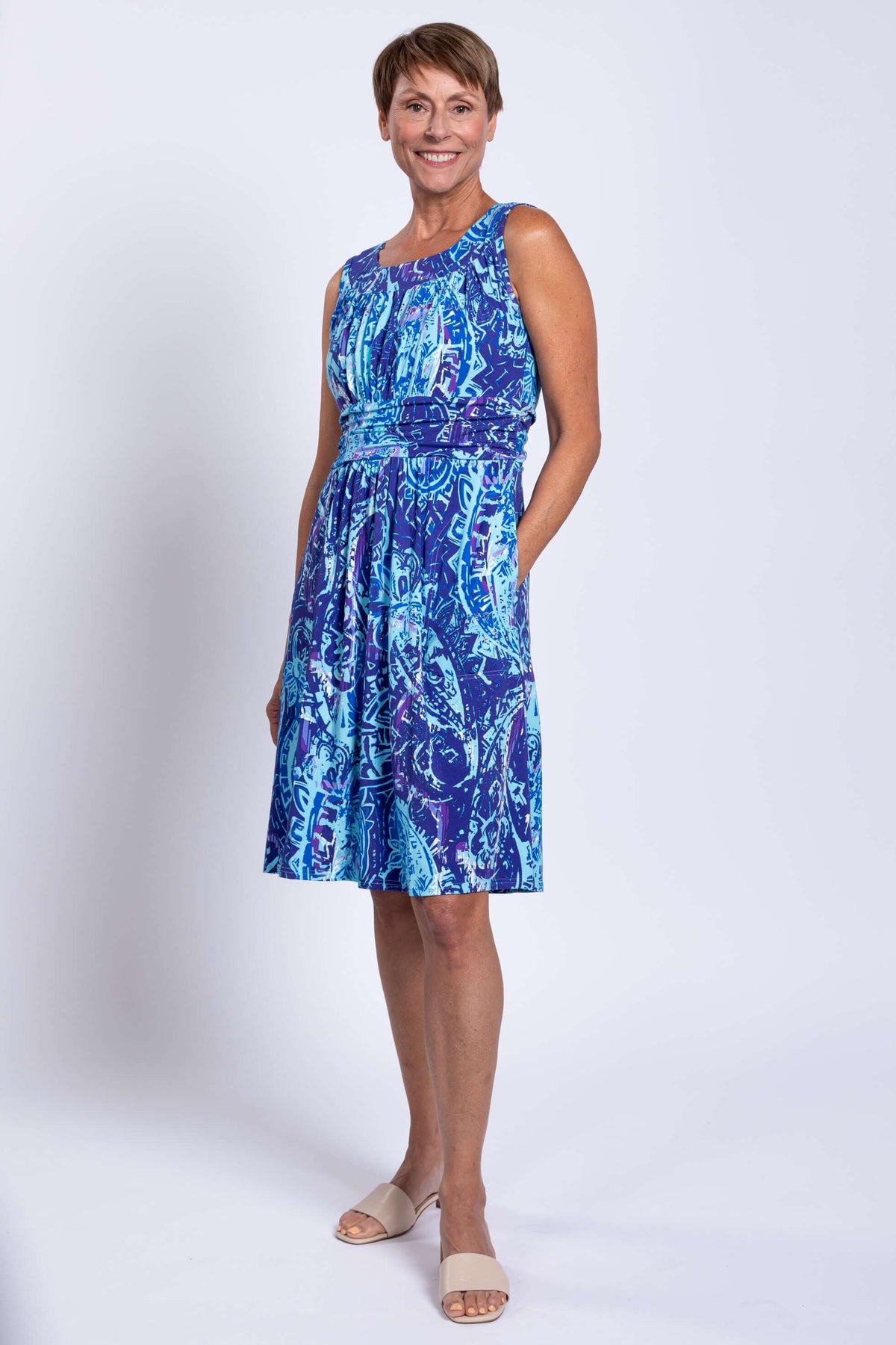 Woman in sleeveless blue patterned Roam dress with pockets