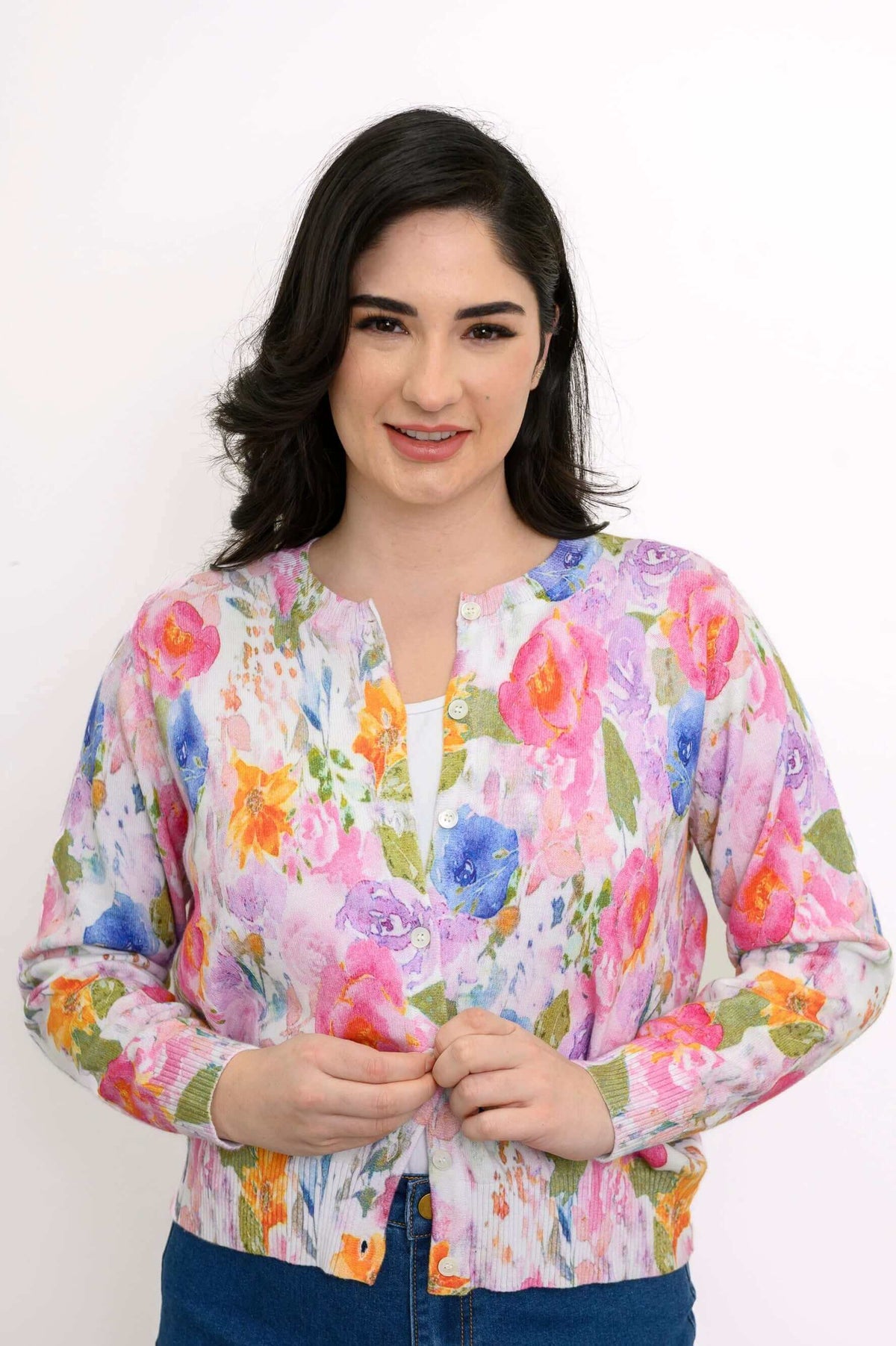 Woman wearing a bright floral cotton cardigan, close-up view against white background