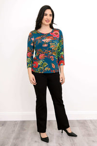 Woman in floral print bamboo tee and black pants, angled standing view