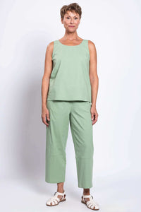 Full-length front view of woman in sleeveless light sage green tank and matching pants