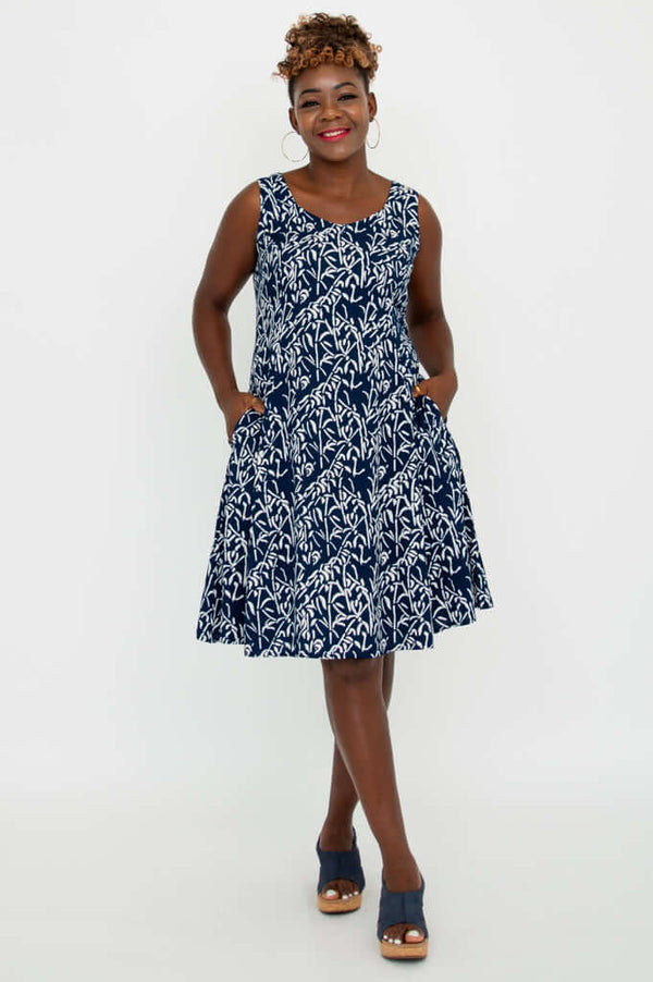 Woman wearing a sleeveless navy and white patterned summer dress with pockets