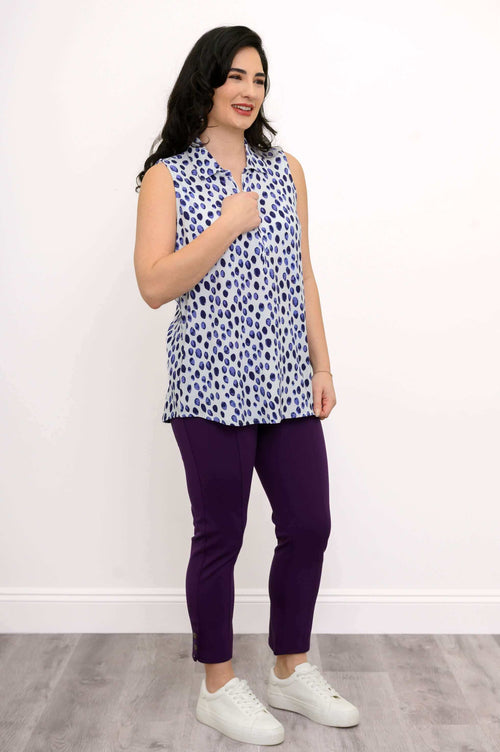 Woman in sleeveless blue and white print tank top and purple ankle pants