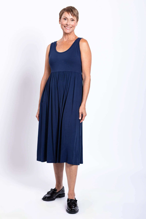Woman in sleeveless indigo midi dress with fitted bodice and gathered skirt
