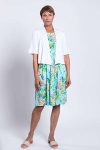Woman modeling a blue floral dress with short white cardigan