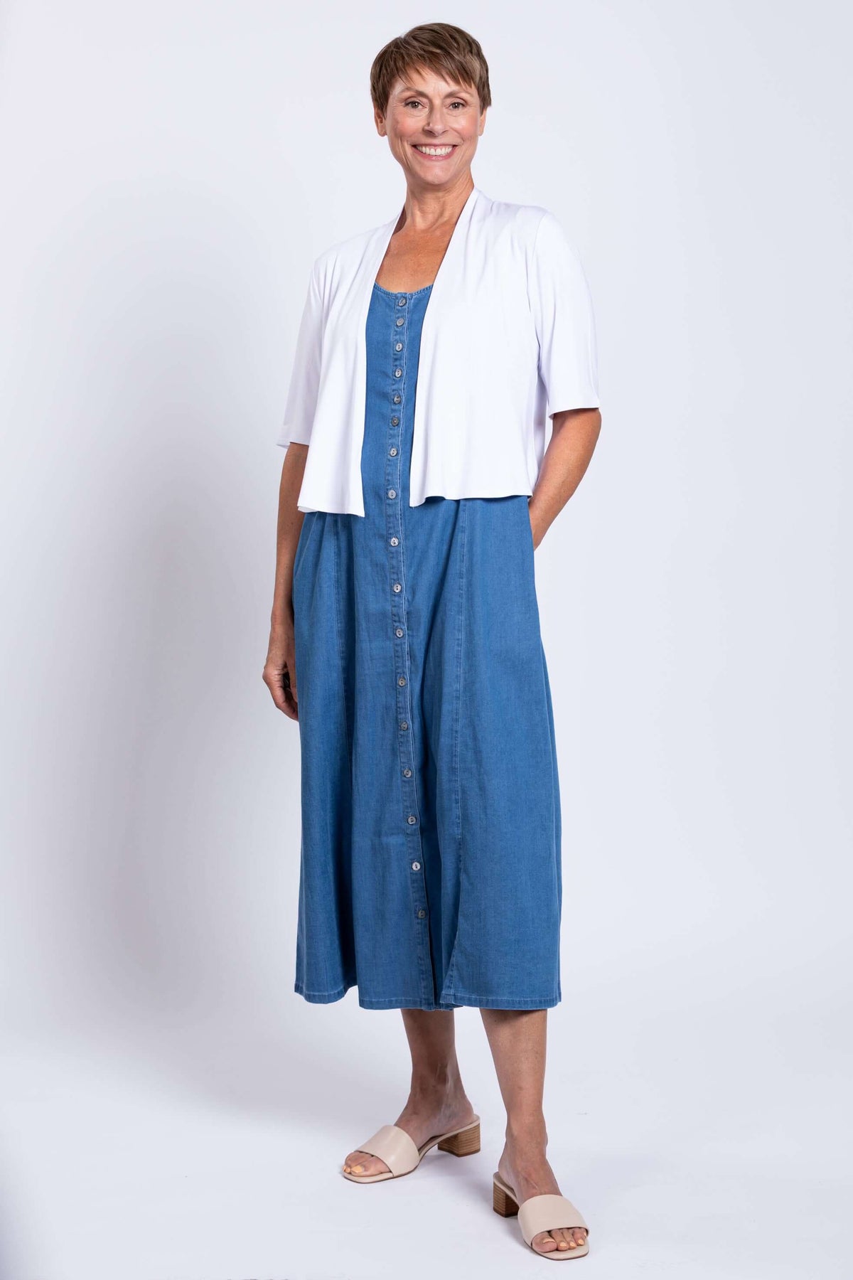Woman modeling blue Tencel denim maxi dress with white cardigan
