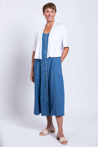 Woman modeling blue Tencel denim maxi dress with white cardigan