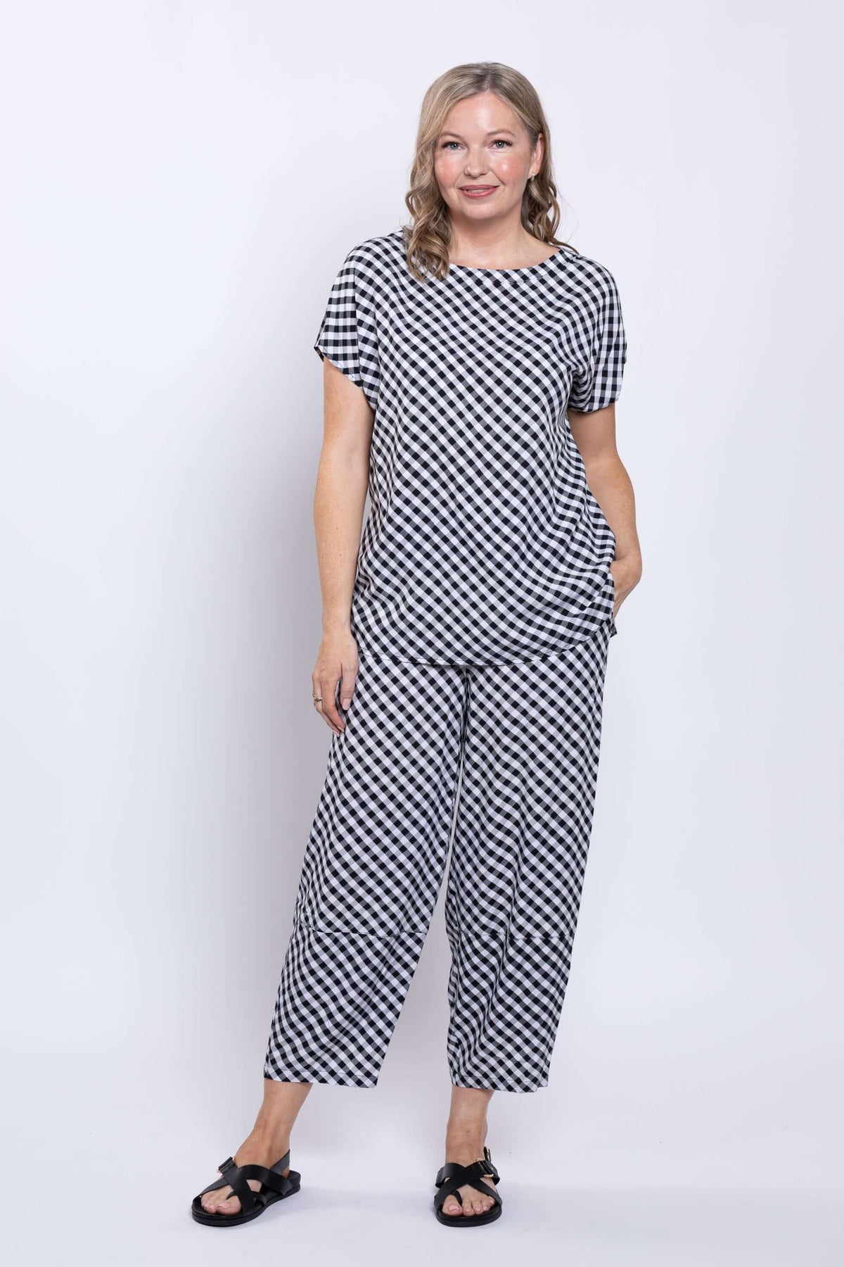 Woman standing in gingham linen blend tee and matching pants on white background