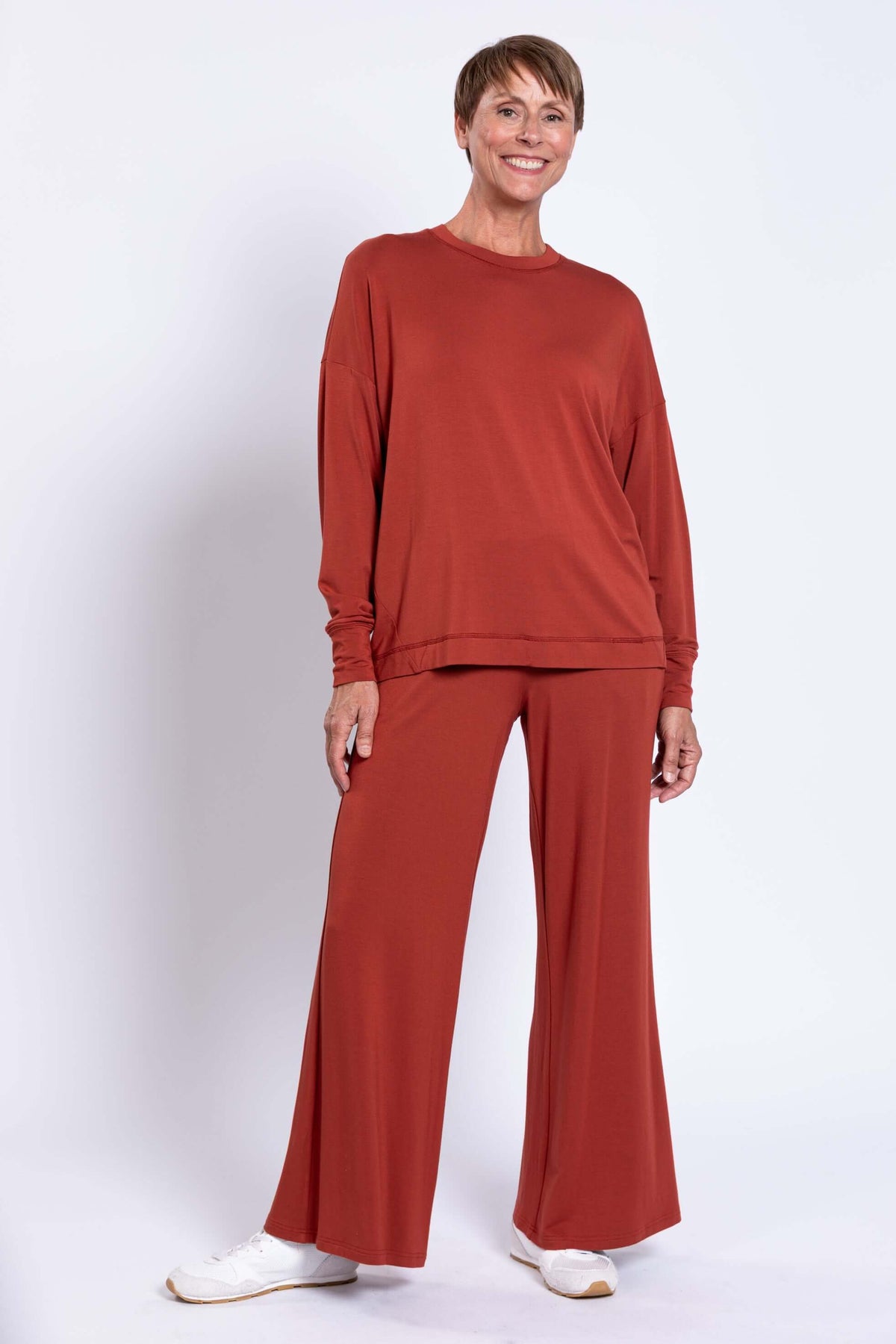 Woman posing with relaxed rust bamboo crew neck top and matching pants
