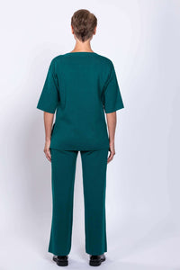 Woman modeling teal wide-leg pants and matching top, back view