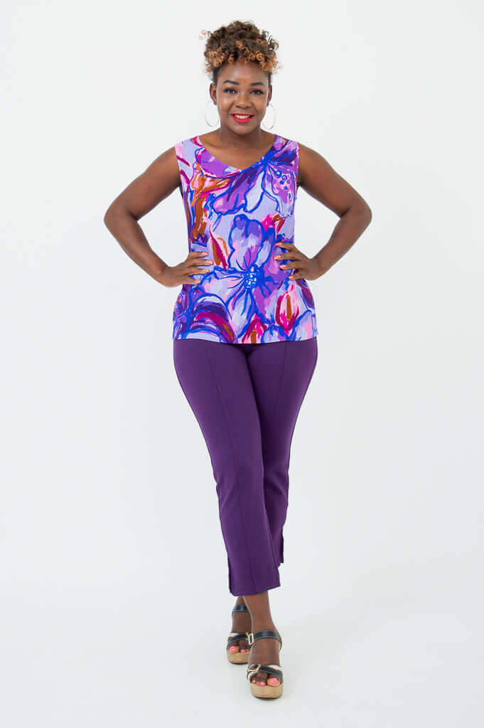 Woman posing confidently in a purple floral V-neck tank and matching pants