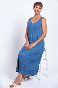Woman seated in a blue Tencel denim maxi dress with button front