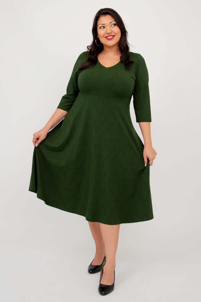 Woman in green dress holding out the skirt to show its flowy A-line shape