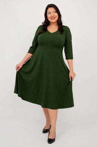 Woman in green dress holding out the skirt to show its flowy A-line shape