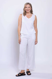 Woman smiling in a white striped sleeveless V-neck tank and pants
