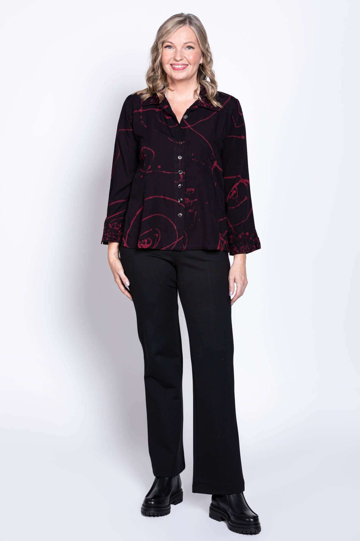 Woman smiling while wearing Ketut blouse with unique red pattern