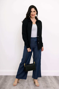 Woman styled in Parker wide leg tencel pants, black shirt, white top, and black handbag