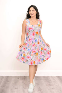 Woman twirling in a sleeveless, colorful floral A-line dress