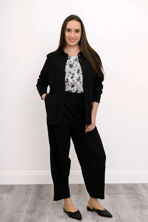 Woman wearing Boardwalk Pants in black with a floral top and black jacket