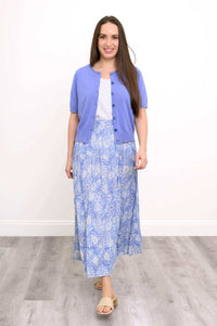 Woman wearing a blue tiered maxi skirt with a purple cardigan and sandals