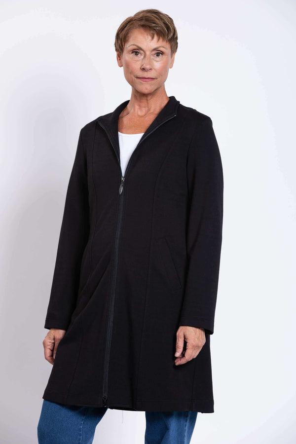 Woman wearing a black long zip-front coat with princess seams and pockets