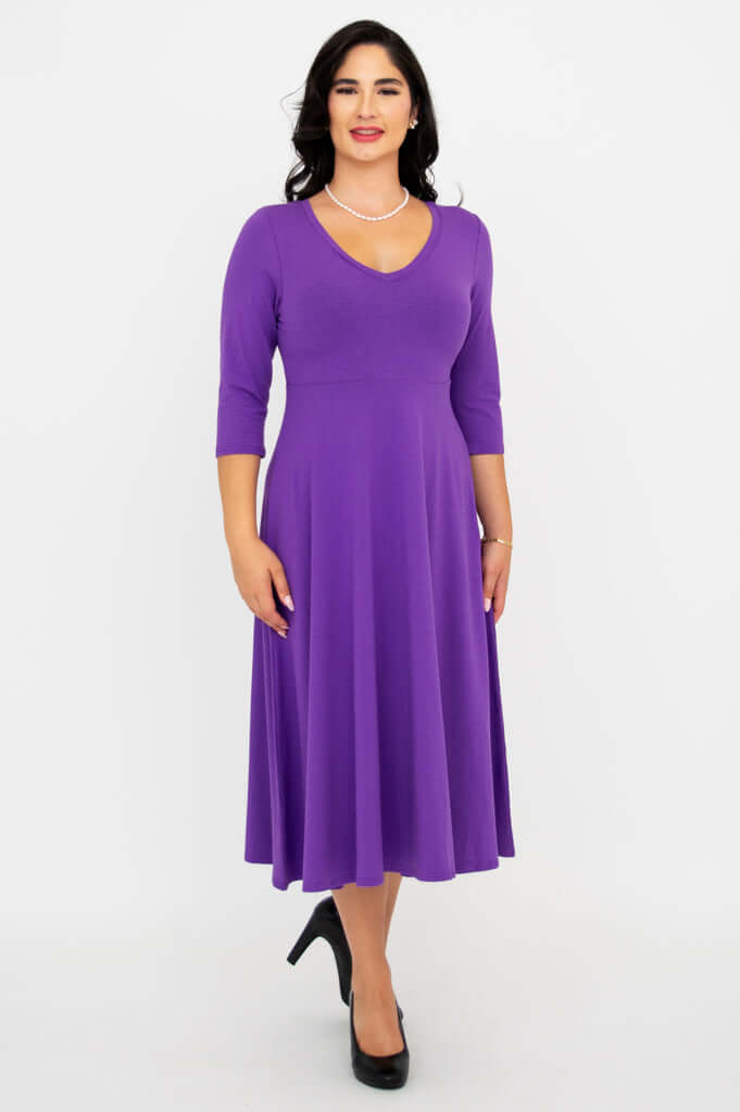 Woman wearing a purple midi-length dress with three-quarter sleeves and V-neckline