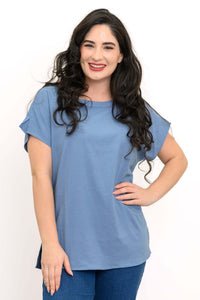 Woman wearing a relaxed blue dolman tee with cap sleeves