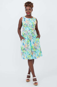Woman wearing a sleeveless blue floral ruched dress with pockets