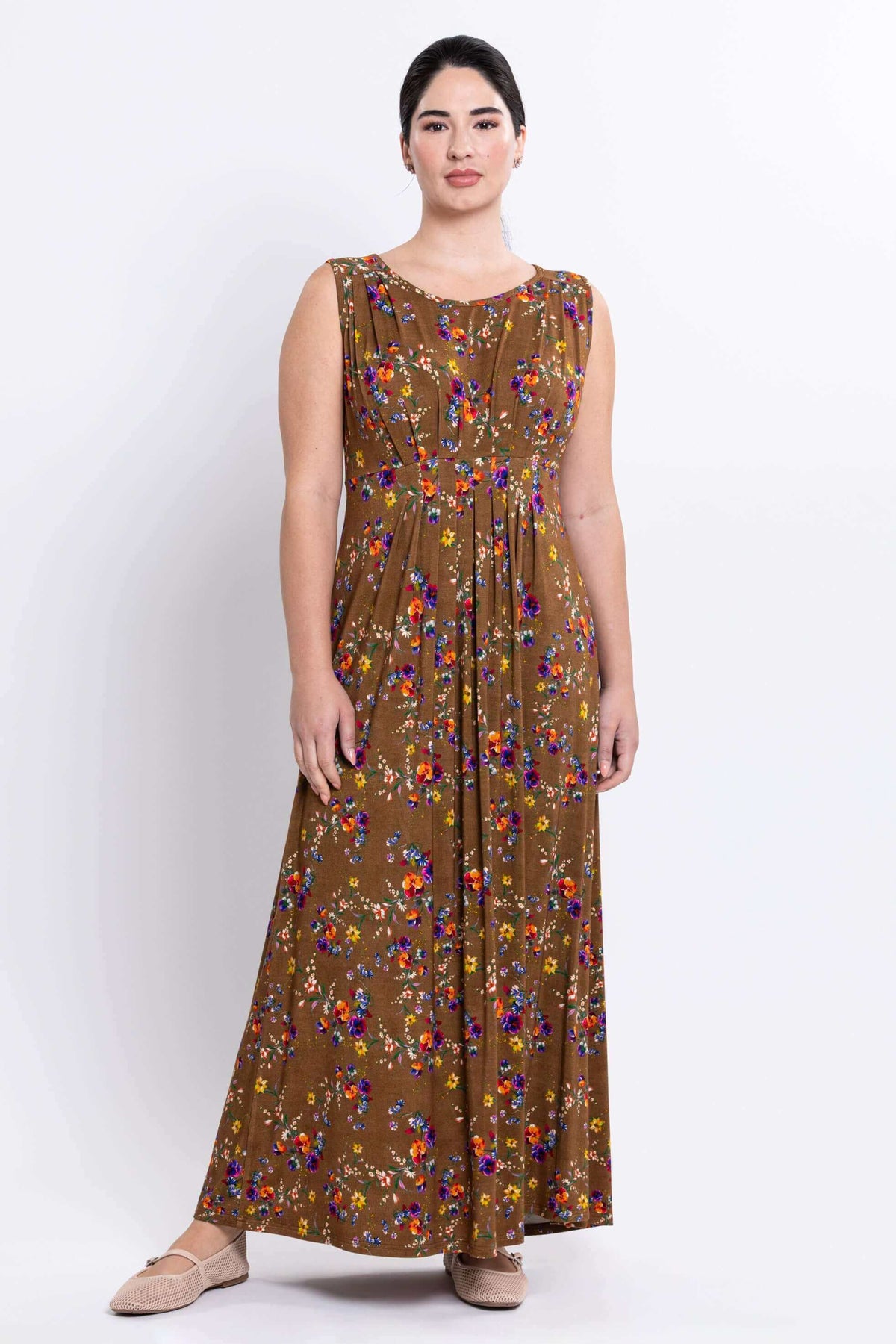 Woman wearing a sleeveless brown floral maxi dress, front view
