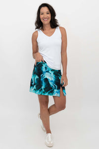 Woman wearing aqua marble Melly skirt-shorts with white tank top