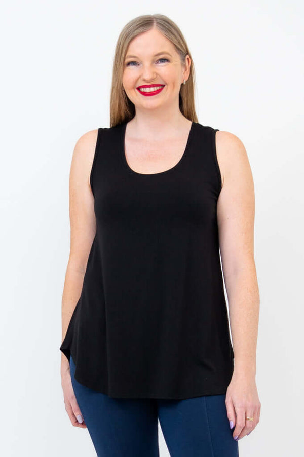 Woman wearing a black bamboo tank top with blue pants, front view, smiling