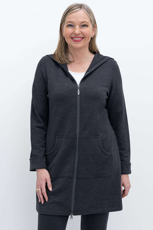 Woman wearing a dark grey hooded jacket with zip closure and front pockets, smiling