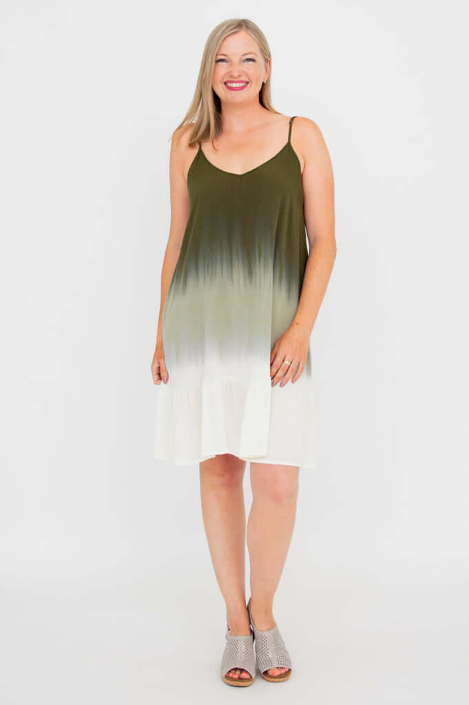 Woman standing straight in olive ombre mini dress, front view, smiling