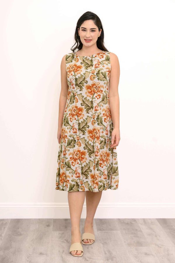 Woman wearing sleeveless floral midi dress in orange and green
