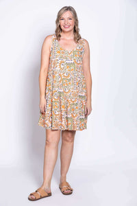 Woman wearing sleeveless patterned Kaya dress with tiered layers, front view