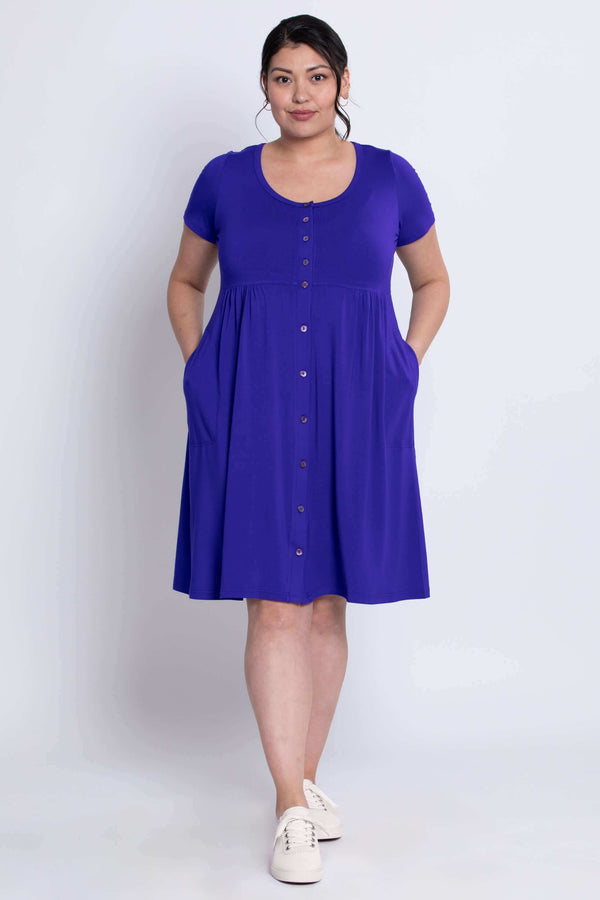 Woman with hands in pockets wearing violet bamboo dress with buttons down the front
