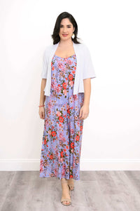 Woman layering a white shrug over a purple floral jumpsuit
