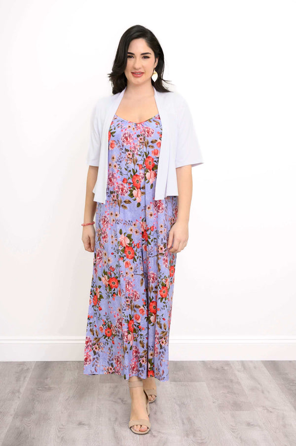 Woman layering a white shrug over a purple floral jumpsuit