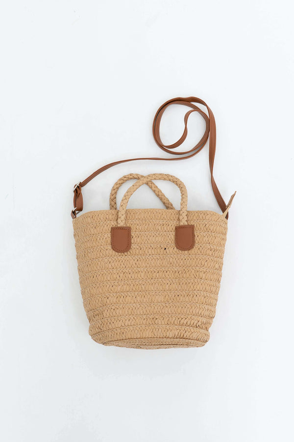 Woven straw tote bag with braided handles and brown leather crossbody strap