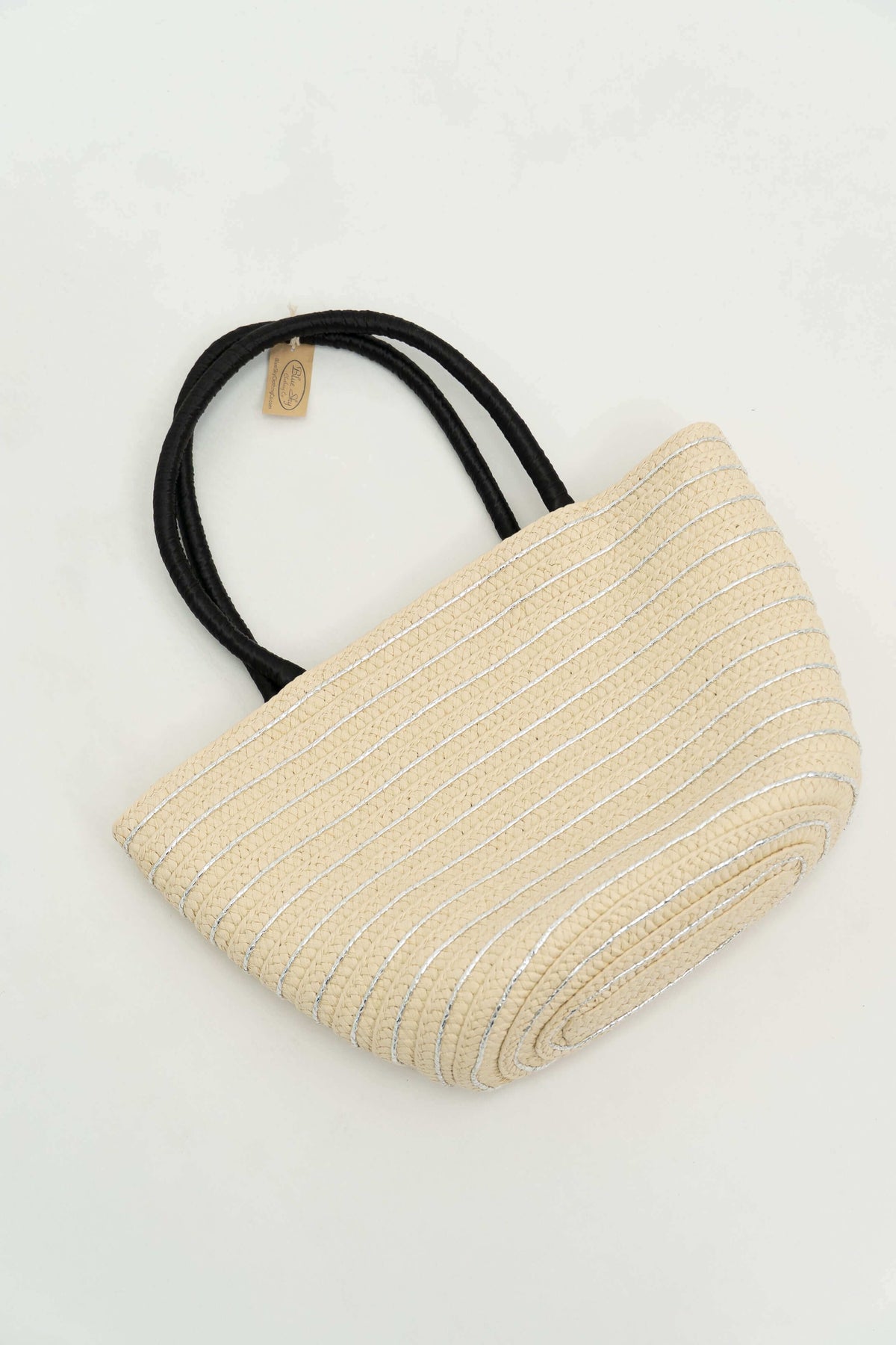 Angled view of woven tote bag with metallic accents and black handles