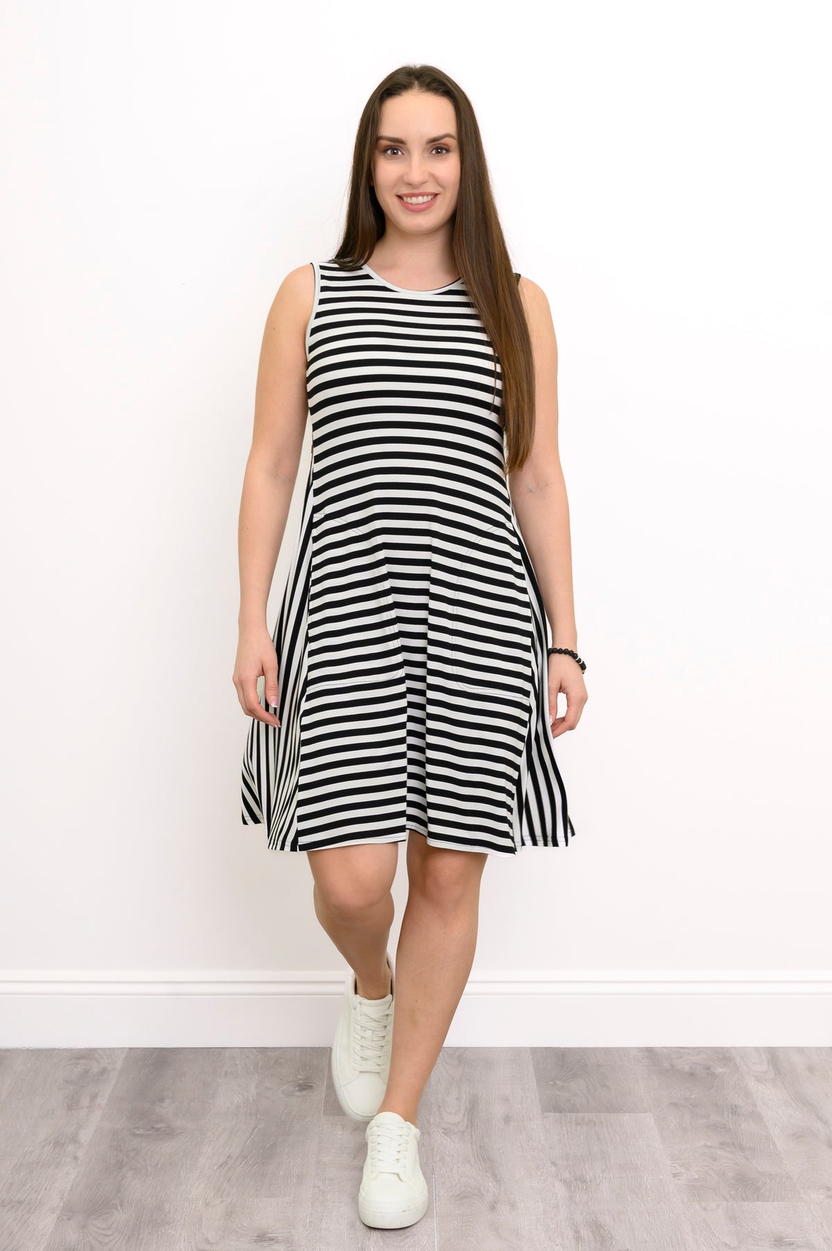 Woman posing in a casual black and white striped A-line bamboo dress with a round neckline.