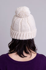 Women's cream beige knit toque wool hat with pompom.
