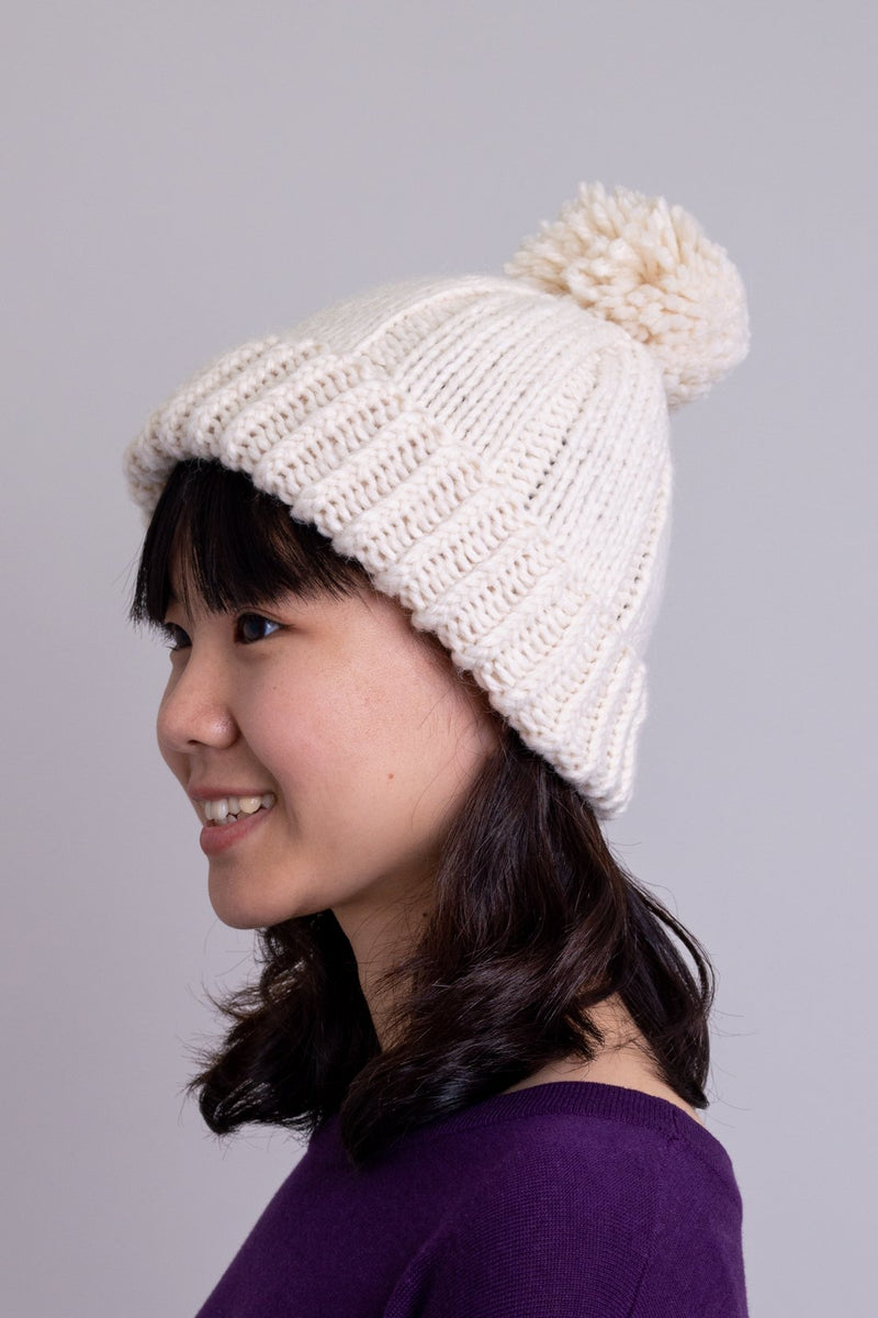 Women's cream beige knit toque wool hat with pompom.