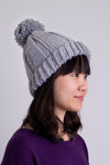 Women's grey knit toque wool hat with pompom.