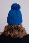 Women's teal blue knit toque wool hat with pompom.